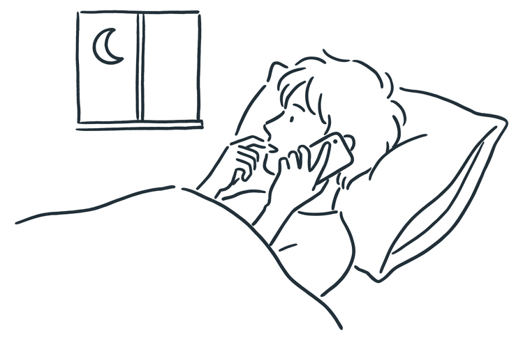 A person lying in bed at night, speaking quietly into their phone.